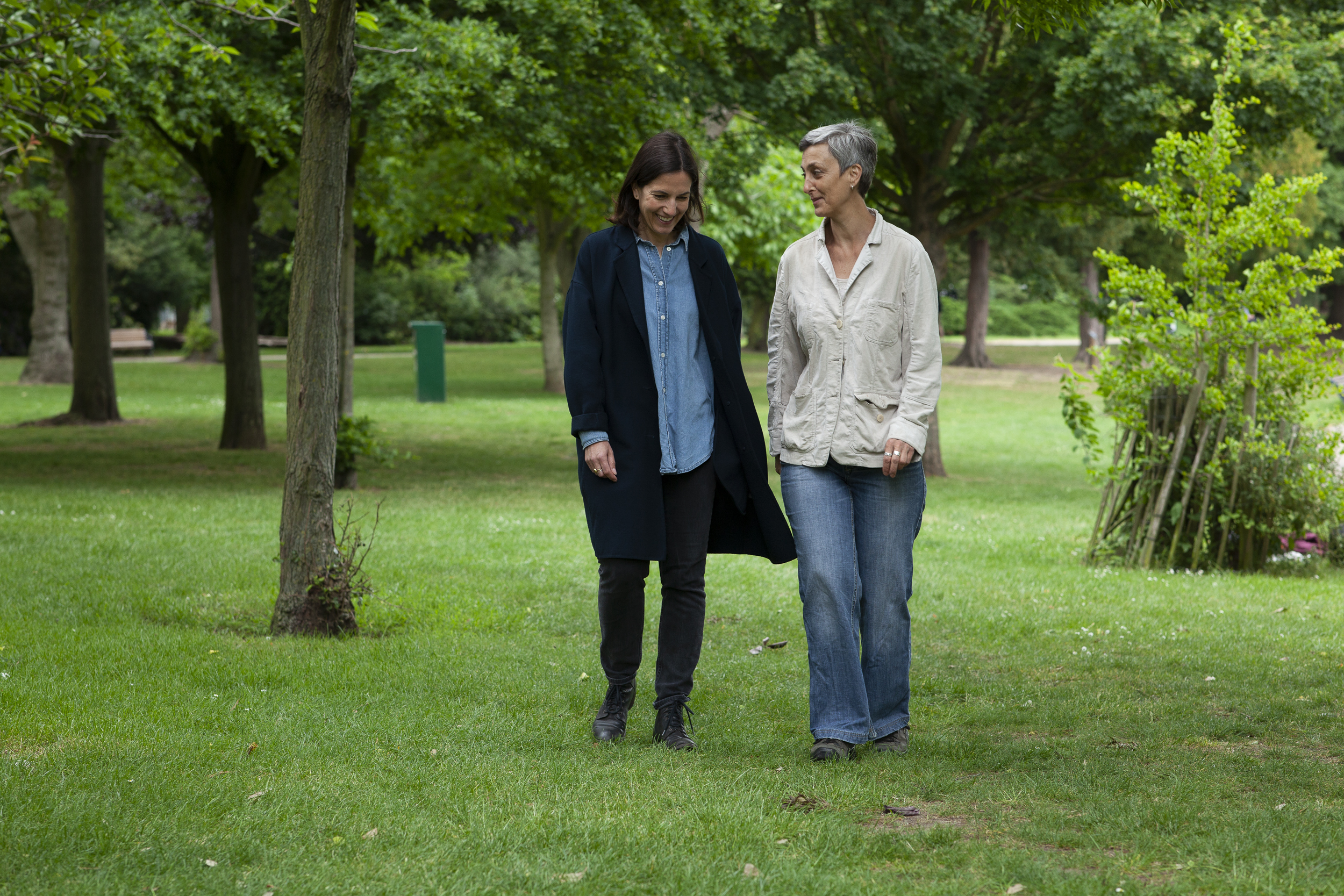 Karen Liebenguth walking with a life coaching client, across the grass in Victoria Park, East London